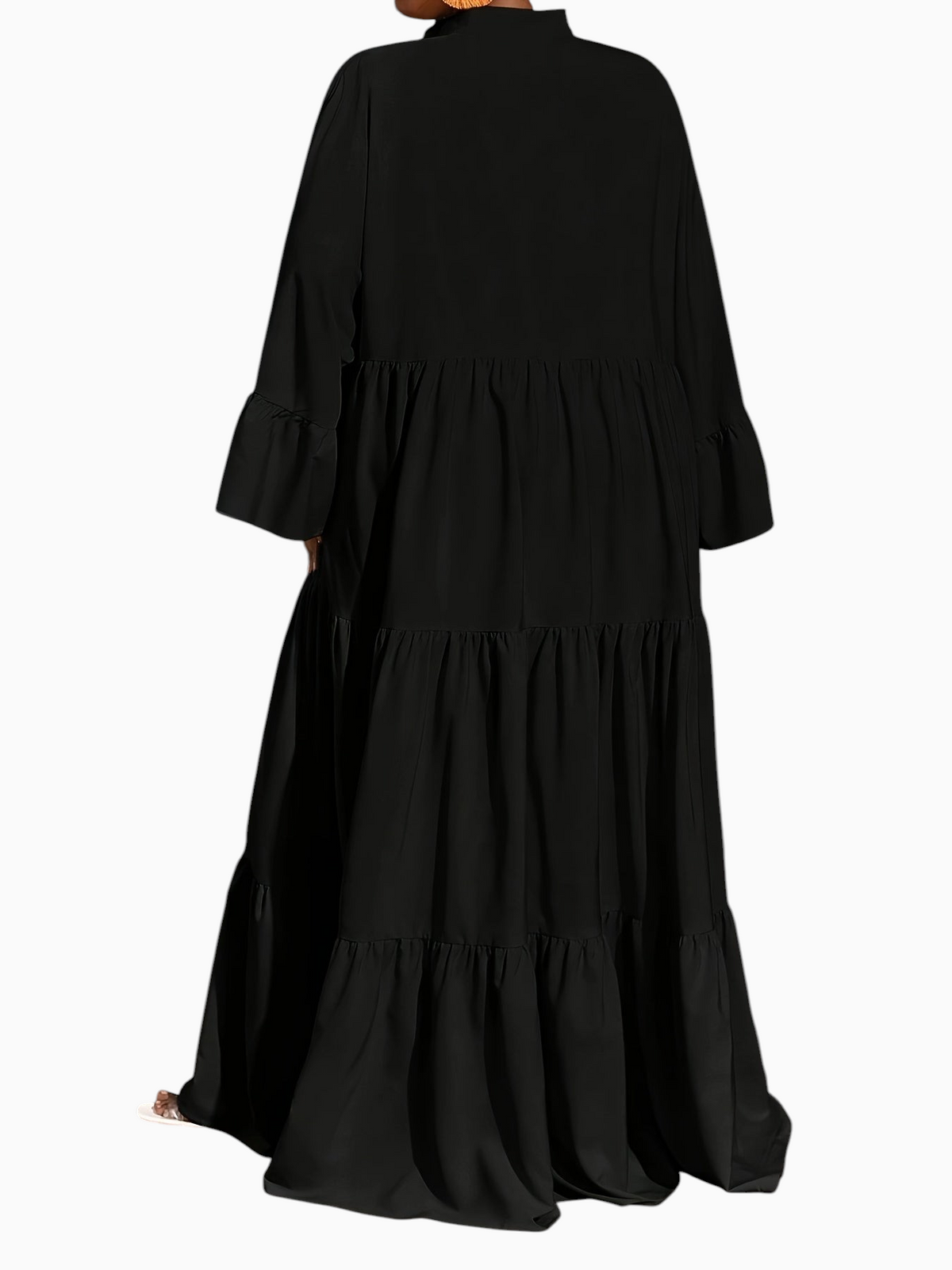 Linen & Loom black midi tunic dress with long sleeves and tiered trapeze hem, worn by a model in a studio setting.