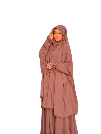 Linen & Loom 2-piece abaya set in dusty rose with lace-up details and matching headscarf worn by a woman outdoors