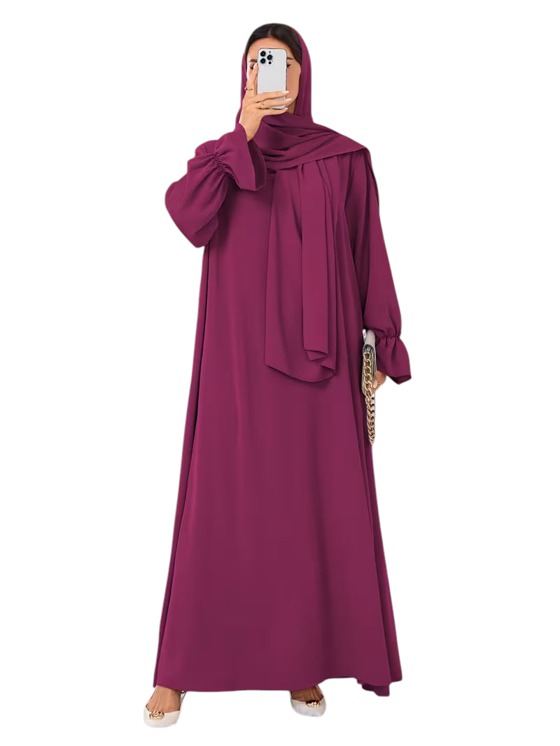 Linen & Loom elegant deep magenta one-piece abaya with flowing bell sleeves and matching hijab in a bright room.