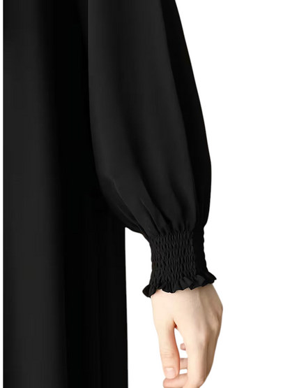 Linen & Loom black abaya featuring long sleeves with elegant smocked cuffs and delicate ruffle detailing