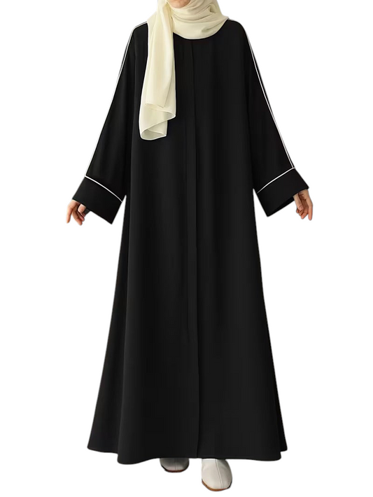 Linen & Loom black abaya with white piping detail, styled with a cream hijab for a modest, elegant look.