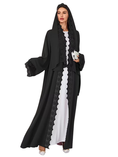 Linen & Loom 2-piece black abaya set with intricate lace trim and beadwork, worn by a model in a bright living room.