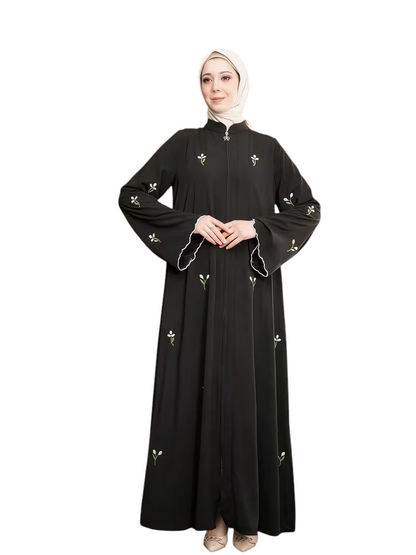 Linen & Loom black full-length abaya featuring delicate white floral embroidery, front zipper, and flared sleeves.