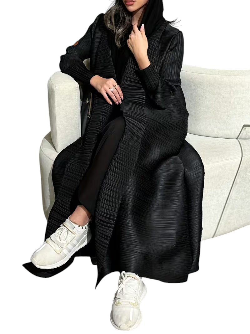 Linen & Loom black plisse abaya with long sleeves and loose fit, worn by a woman sitting on a white sofa.