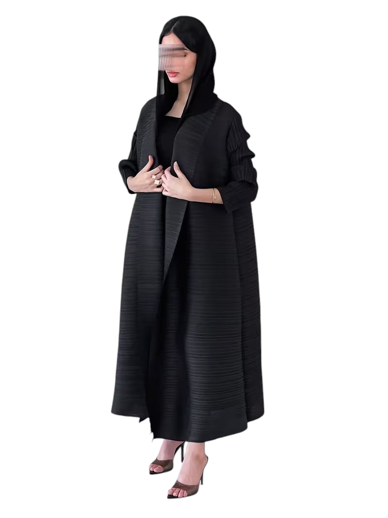 Linen & Loom elegant black plisse abaya with long sleeves and loose fit, worn by a model in a minimalist room.