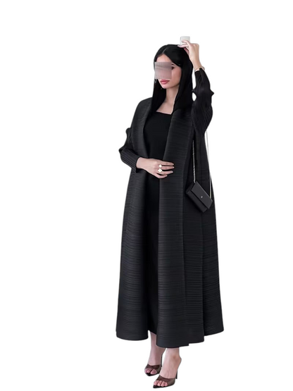 Linen & Loom black plisse abaya with long sleeves and loose fit, worn by a model in a modern minimalist interior.