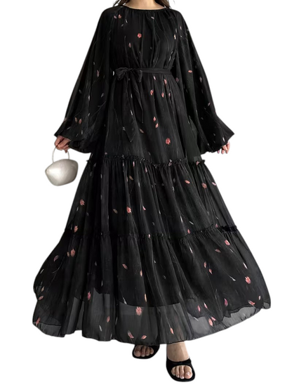 Linen & Loom black chiffon abaya dress with a floral print, long sleeves, tiered skirt, and a matching waist belt.