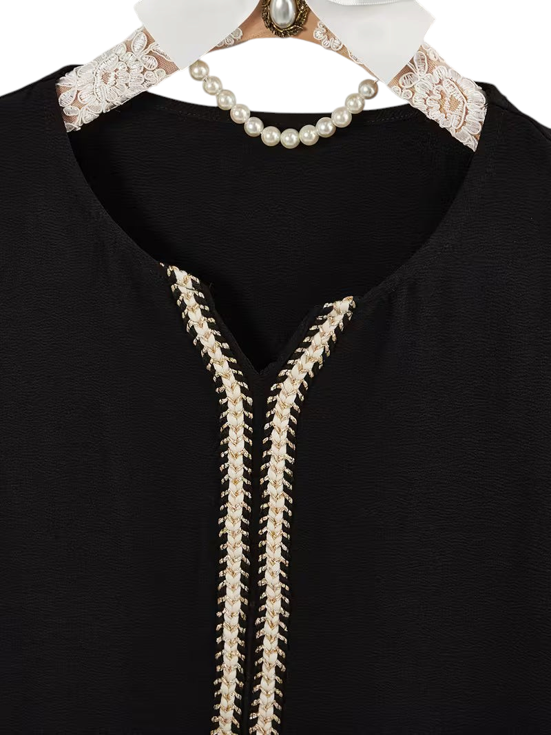 Linen & Loom black Arab-style daily dress featuring a modest V-neckline with intricate cream and gold braided trim.
