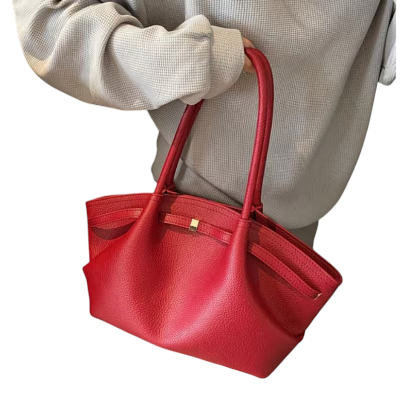 Linen & Loom red textured leather tote handbag with double handles held by a person in a casual grey sweatshirt