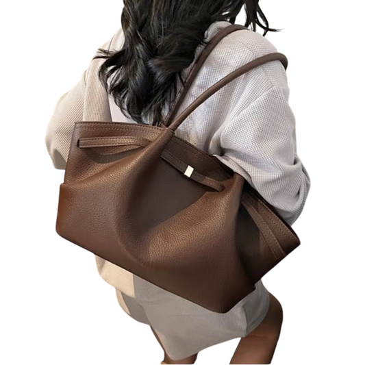 Linen & Loom brown leather tote handbag with double handles worn over the shoulder by a woman in a casual outfit.