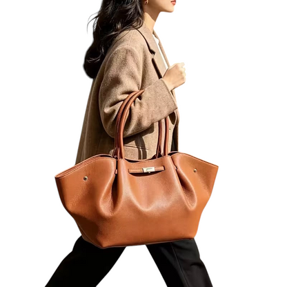 Linen & Loom light brown lychee-grain leather tote bag with a spacious design carried by a woman on a city street.